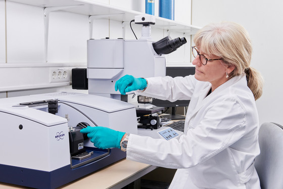 Eine Chemikerin arbeitet an einem IR-Spektrometer (FTIR)